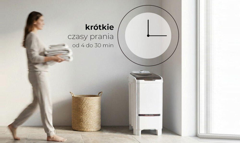 Osoba niesie stos ręczników obok pralko-wirówki stojącej przy ścianie. Na ścianie widoczny jest napis: \'krótkie czasy prania od 4 do 30 min\' oraz grafika zegara.