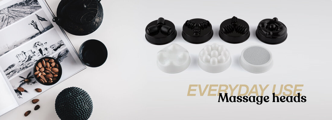 Na zdjęciu widoczne są różne głowice do masażera w kolorach czarnym i białym. Obok znajduje się tekst: \'EVERYDAY USE Massage heads\'.
