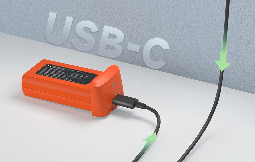 Pomarańczowa bateria z podłączonym kablem USB-C, na tle widoczny napis \'USB-C\'.