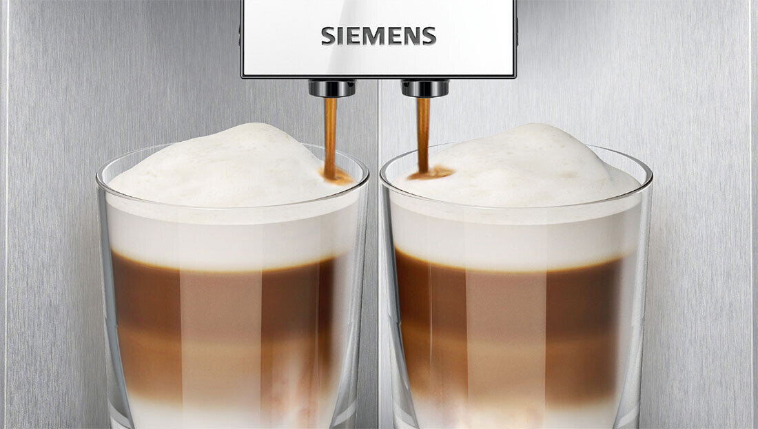 Dwa szklane kubki z kawą z mleczną pianką, pod którymi znajduje się ekspres do kawy z logo SIEMENS.