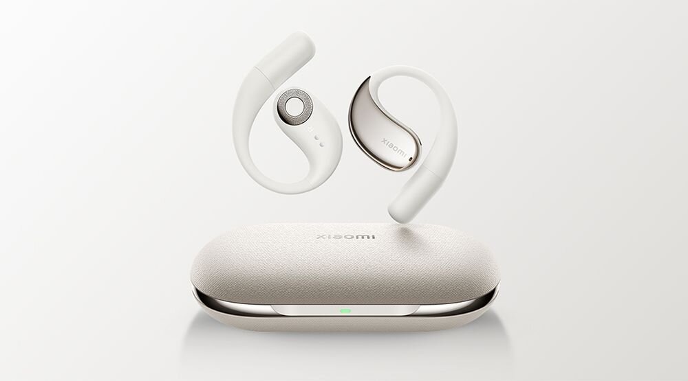 Na obrazie widoczne są beżowe słuchawki douszne oraz etui z logo \'xiaomi\'. Słuchawki mają nowoczesny design z zakrzywionymi elementami.