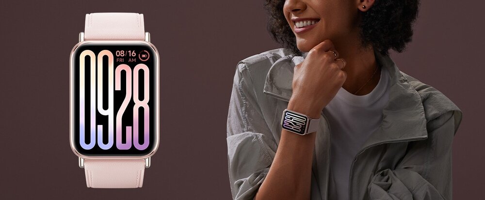 Na obrazie widoczny jest smartwatch z jasnym paskiem i dużym wyświetlaczem pokazującym godzinę 09:28. Obok znajduje się osoba nosząca ten sam model zegarka na nadgarstku.