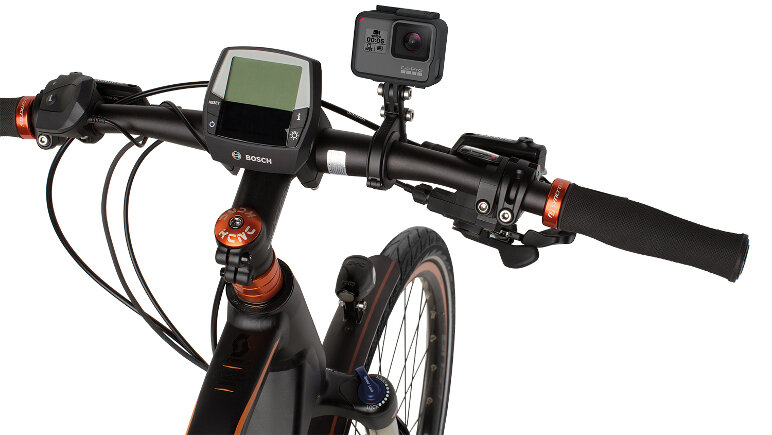 Kierownica roweru z zamontowaną kamerą sportową na uchwycie oraz wyświetlaczem z logo \'Bosch\'.