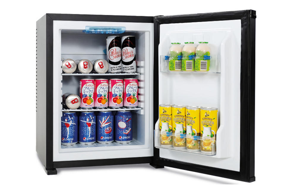Otwarta lodówka z napojami w puszkach i butelkach na półkach oraz drzwiach. W lodówce znajdują się różne marki napojów, w tym Pepsi i inne napoje gazowane.