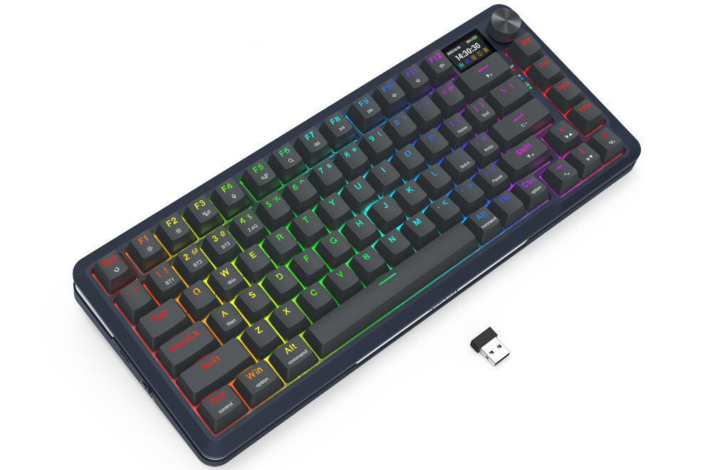 Klawiatura mechaniczna z podświetleniem RGB, posiada klawisze funkcyjne oznaczone od F1 do F12 oraz pokrętło w prawym górnym rogu. Obok klawiatury znajduje się mały adapter USB.