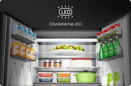 Wnętrze lodówki z otwartymi drzwiami, wypełnione różnorodnymi produktami spożywczymi, takimi jak napoje, warzywa i ciasta. Na górze widoczny jest napis \'Oświetlenie LED\'.