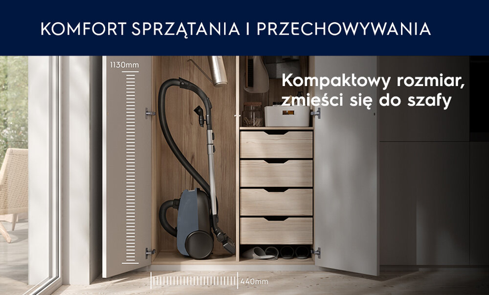 Odkurzacz umieszczony w szafie obok szuflad, z widocznymi wymiarami 1130 mm i 440 mm. Tekst na obrazie: \'KOMFORT SPRZĄTANIA I PRZECHOWYWANIA\' oraz \'Kompaktowy rozmiar, zmieści się do szafy\'.
