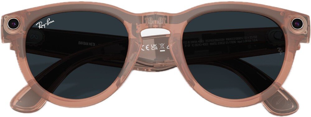 Okulary przeciwsłoneczne w kolorze brzoskwiniowym z ciemnymi soczewkami i logo \'Ray-Ban\' na jednym z zauszników. Na oprawkach widoczne są małe kamery po obu stronach.