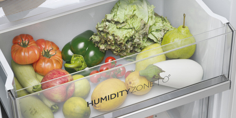 Wnętrze lodówki z szufladą oznaczoną napisem \'HUMIDITY ZONE\', wypełnioną różnymi warzywami i owocami, takimi jak sałata, papryka, pomidory, gruszka i cytryna.