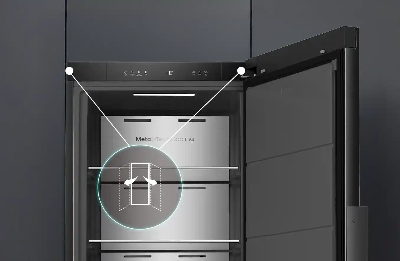 Otwarta zamrażarka z ciemnym wnętrzem i napisem \'Metal-Tech Cooling\' na tylnej ścianie. Na górnym panelu widoczne są ikony i przyciski sterujące.