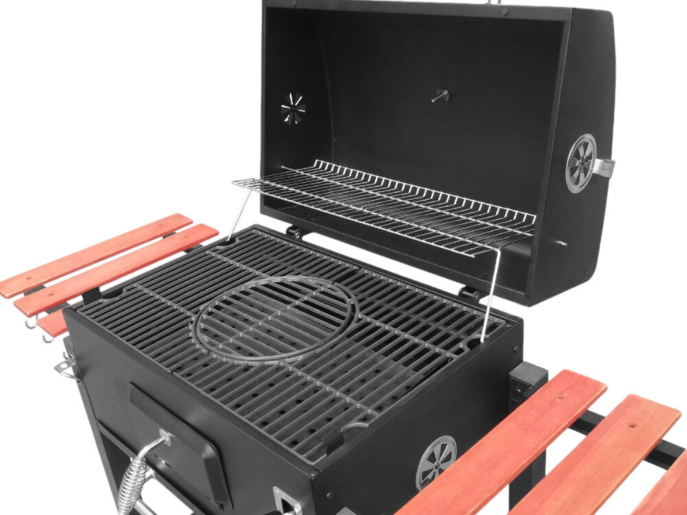 Grill węglowy z otwartą pokrywą, wyposażony w żeliwny ruszt i dodatkową półkę na akcesoria. Po bokach znajdują się drewniane półki, a na pokrywie widoczny jest termometr.