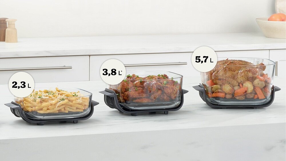 Na blacie kuchennym znajdują się trzy szklane pojemniki z jedzeniem, oznaczone pojemnościami: 2,3 L, 3,8 L i 5,7 L. W pojemnikach znajdują się frytki, mięso z sosem oraz pieczone mięso z warzywami.