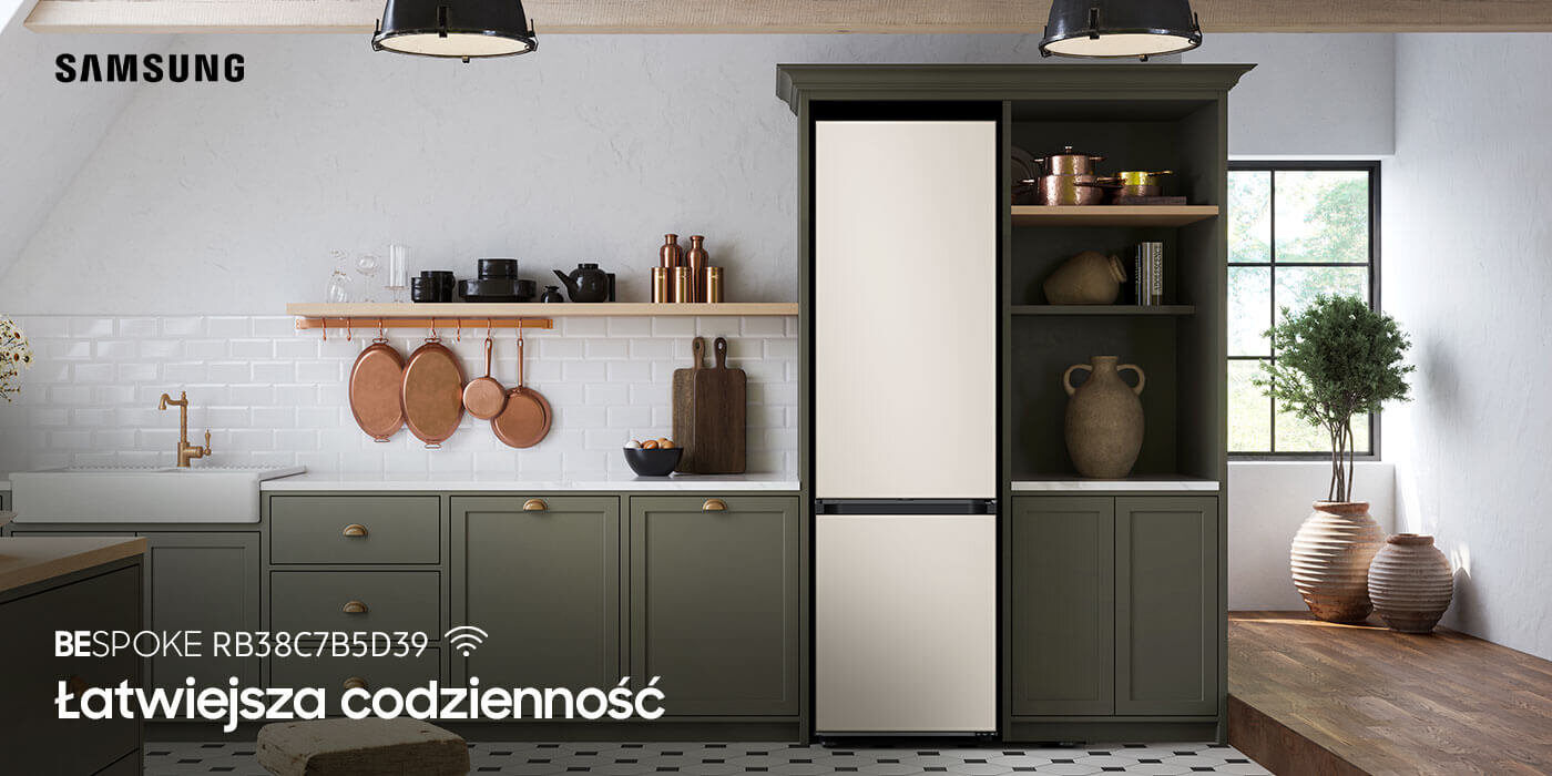 lodówka Samsung Bespoke RB38C7B5D39 w kolorze satynowego beżu dostępna w Media Expert Kuchnia z lodówką w zabudowie, z satynowo-beżowymi drzwiami, otoczona zielonymi szafkami. Na ścianie widoczne są drewniane półki z naczyniami i dekoracjami, a na dole napis: \'BESPOKE RB38C7B5D39 Łatwiejsza codzienność\'.