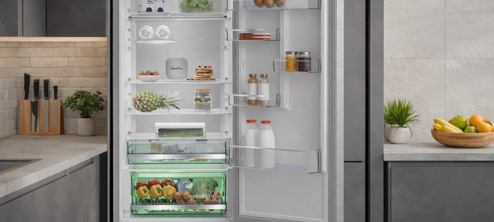 LODÓWKA BEKO B3RCNA415HXBR Obraz przedstawia otwartą lodówkę w kuchni, wypełnioną produktami i wyposażoną w szufladę HarvestFresh. Zdjęcie eksponuje praktyczne rozmieszczenie półek i estetyczne wykończenie wnętrza oświetlenie LED alarm otwartych drzwi BottleFlex półka na butelki metalowa tylna ściana higiena