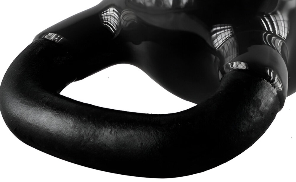 Czarny kettlebell z metalowym uchwytem, odbijający światło na powierzchni.