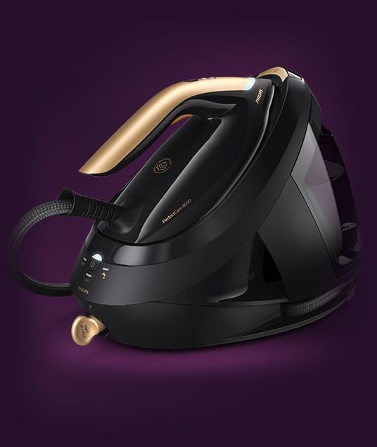 Czarny generator pary z elementami w kolorze złotym, z widocznym napisem \'PerfectCare 8000\' oraz logo \'PHILIPS\'. Urządzenie ma ergonomiczny uchwyt i wężyk parowy.