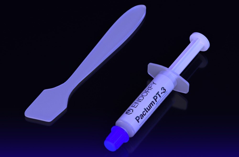 Na obrazie widoczna jest strzykawka z napisem \'ENDORFY Pactum PT-3\' oraz plastikowa szpatułka, obie w kolorze białym na ciemnym tle.