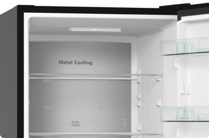 Wnętrze lodówki z widocznymi półkami i napisem \'Metal Cooling\' oraz \'Pure Fresh\' na tylnej ściance.