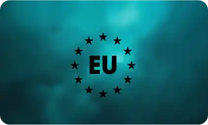 Na tle w odcieniach niebieskiego znajduje się czarny napis \'EU\' otoczony dwunastoma czarnymi gwiazdami ułożonymi w okrąg.
