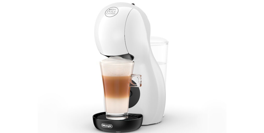 Biały ekspres do kawy z logo \'Dolce Gusto\' na górze, przygotowujący kawę w przezroczystej szklance. Na podstawie widoczne jest logo \'DeLonghi\'.