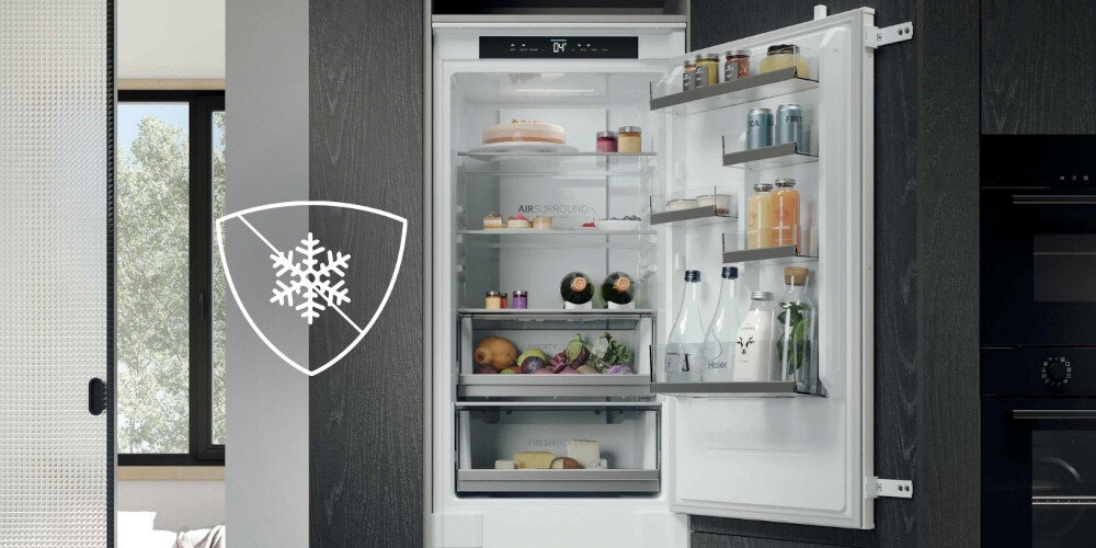 Otwarta lodówka z widocznymi półkami wypełnionymi różnymi produktami spożywczymi, takimi jak napoje, owoce i słoiki. Na drzwiach lodówki znajduje się symbol płatka śniegu w tarczy.