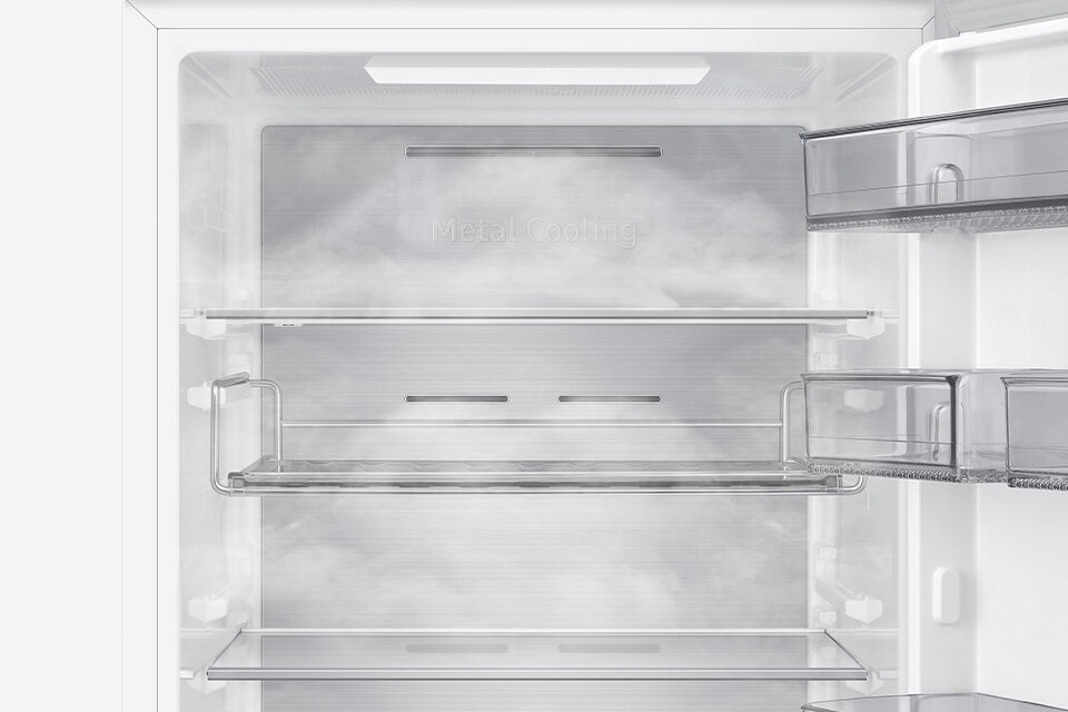 Wnętrze lodówki z metalowym panelem z napisem \'Metal Cooling\', wyposażone w przezroczyste półki i szuflady.