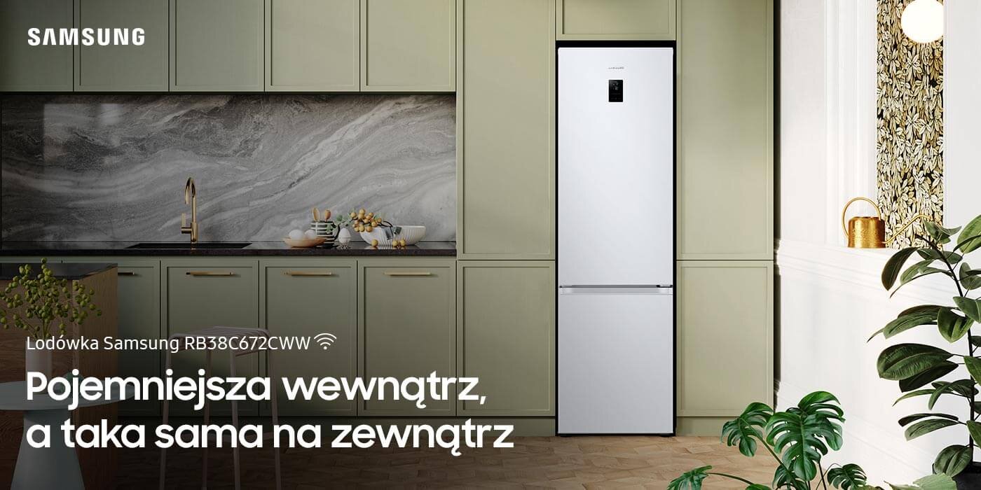 Biała lodówka Samsung RB38C672CWW stoi w eleganckiej kuchni z zielonymi szafkami i marmurowym blatem. Na obrazie widoczny jest tekst: \'Lodówka Samsung RB38C672CWW Pojemniejsza wewnątrz, a taka sama na zewnątrz\'.