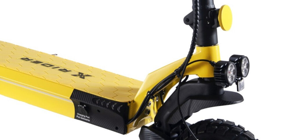Czarno-żółta hulajnoga elektryczna z widocznym napisem \'XRIDER\' na platformie. Posiada dwa reflektory z przodu oraz napis \'Charging Port\' na boku.