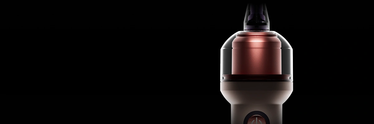 Zbliżenie na okrągły zbiornik na jasnoróżowej szczoteczce Dyson CameraJet