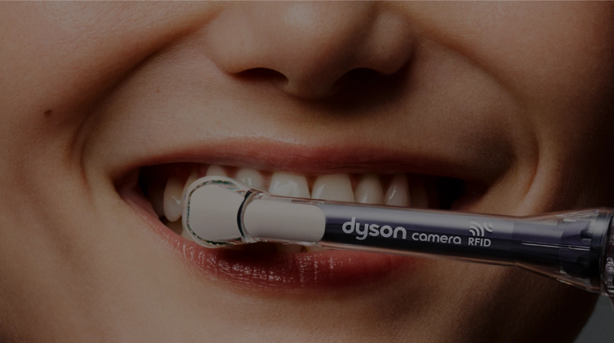 Zbliżenie na kobiece usta i końcówkę do szczoteczki Dyson CameraJet pokazane podczas mycia zębów