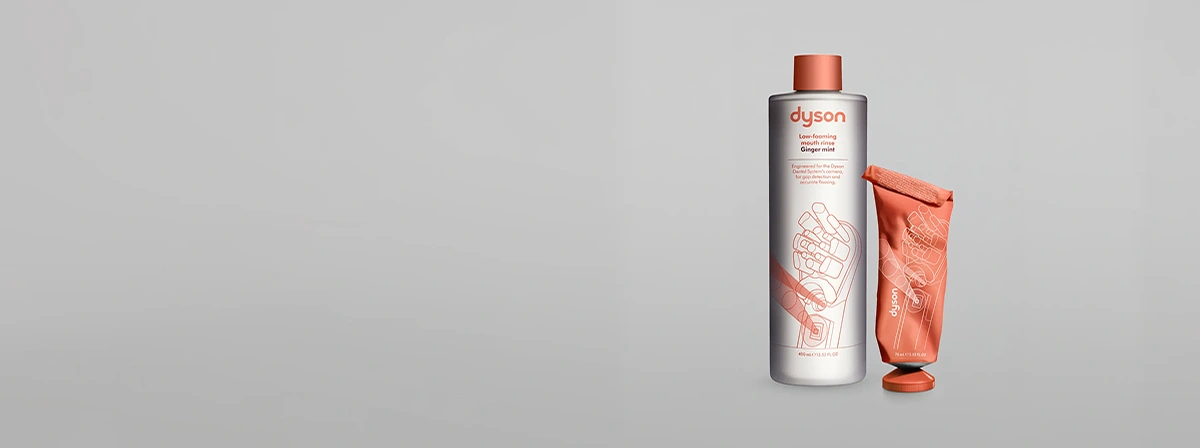 Płyn do płukania jamy ustnej Dyson Ginger Mint w butelce z pomarańczową nakrętką i pomarańczowa tubka pasty Dyson Ginger Mint