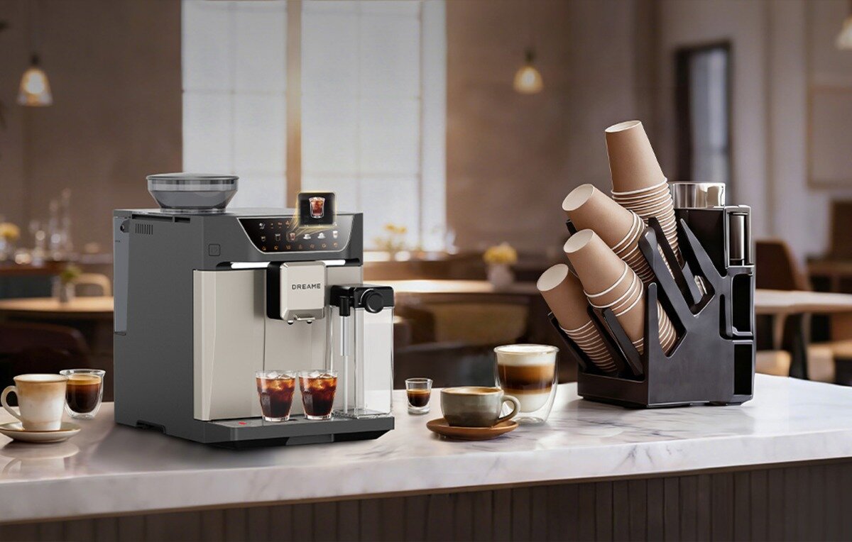 Ekspres DREAME Ecceluxe Master Coffee FCM60 Ekspres do kawy Dreame na ladzie, dwie szklanki mrożonej kawy, filiżanki oraz stojak z papierowymi kubkami