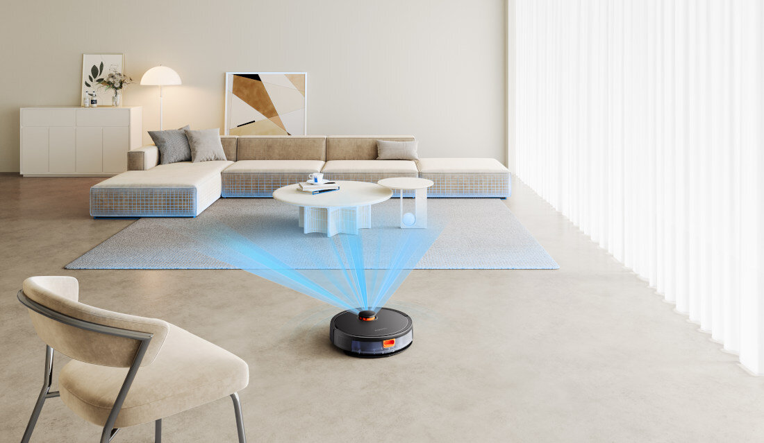 W nowoczesnym salonie na podłodze znajduje się robot sprzątający z niebieskimi promieniami świetlnymi. W tle widoczna jest jasna sofa, stolik kawowy i dekoracje ścienne.