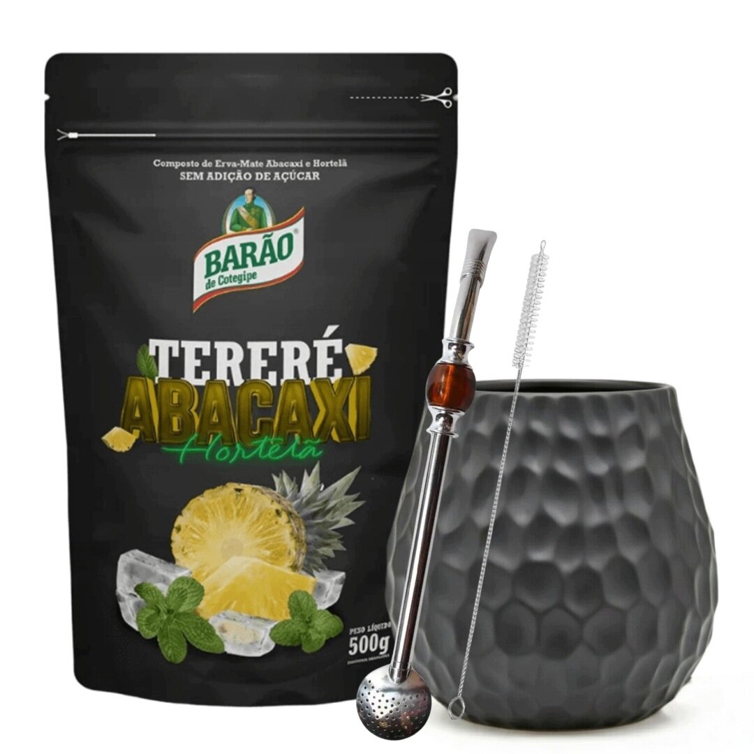 Na obrazie widoczna jest czarna torebka z napisem \'BARÃO Tereré Abacaxi Hortelã\' oraz grafika ananasa i mięty. Obok znajduje się czarny kubek o fakturze plastra miodu, metalowa bombilla i szczoteczka do czyszczenia.