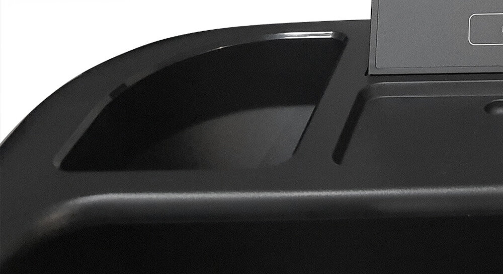 Czarny panel z wnęką, prawdopodobnie część urządzenia elektronicznego.