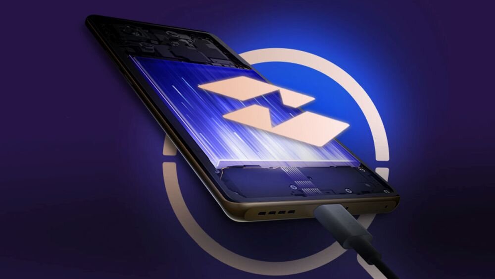 Smartfon w kolorze złotym z podłączonym kablem, na ekranie widoczne są niebieskie linie i symbol przypominający błyskawicę. W tle znajduje się okrągły, niebieski wzór.