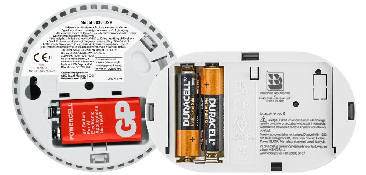 Obraz przedstawia wnętrze czujnika tlenku węgla z widocznymi bateriami GP i Duracell oraz etykietami z informacjami technicznymi. Na etykietach znajdują się oznaczenia modelu 2030-DSR oraz instrukcje dotyczące użytkowania i bezpieczeństwa.