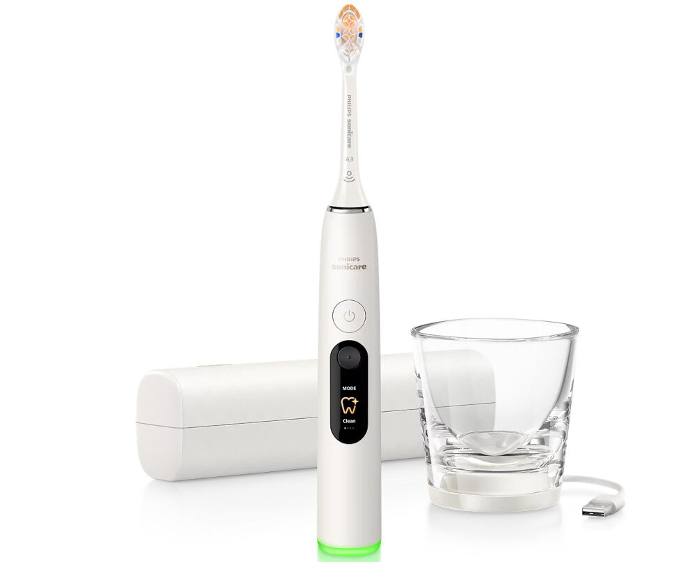 Biała szczoteczka soniczna z wyświetlaczem i przyciskiem zasilania, obok znajduje się szklanka i etui. Na szczoteczce widoczny jest napis \'PHILIPS Sonicare\'.