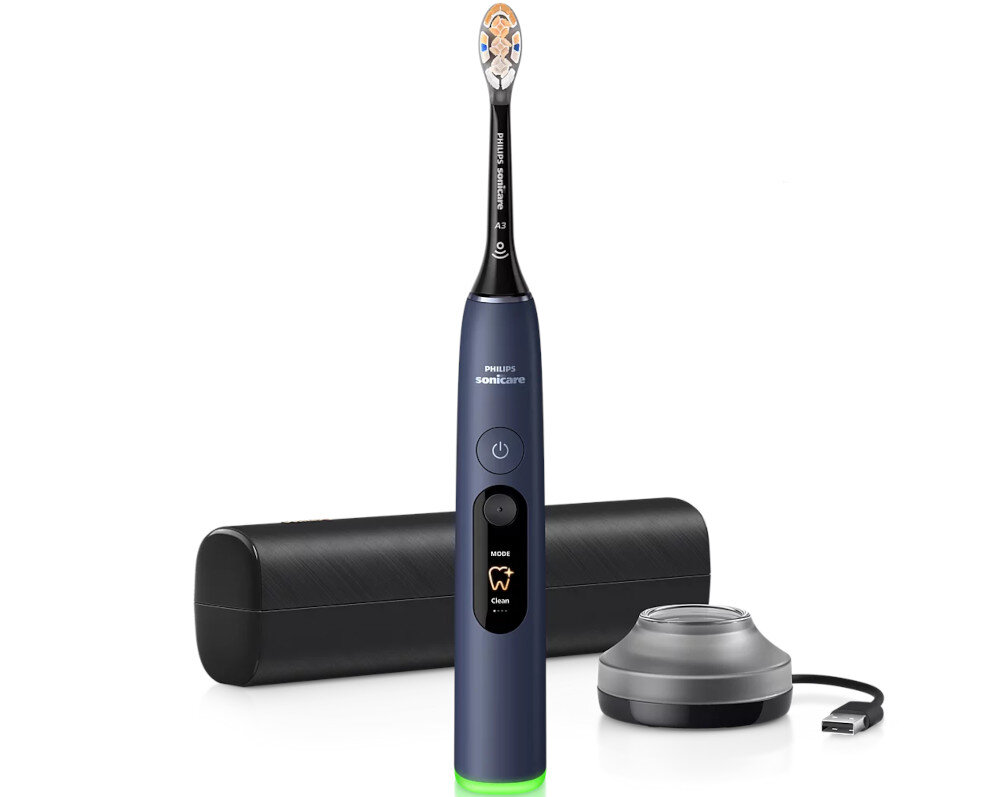 Na obrazie widoczna jest granatowa szczoteczka soniczna z napisem \'Philips Sonicare\' na rączce, obok której znajduje się etui i ładowarka z kablem USB. Szczoteczka ma przycisk zasilania oraz przycisk z napisem \'MODE Clean\'.