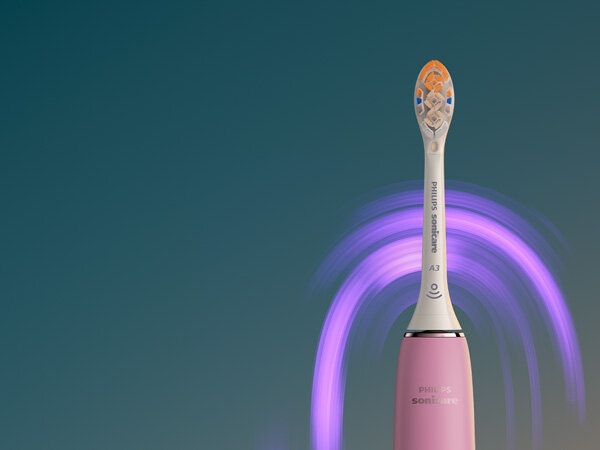 Różowa szczoteczka soniczna z widoczną główką i napisem \'Philips Sonicare A3\'. W tle widoczne są fioletowe smugi na ciemnym tle.