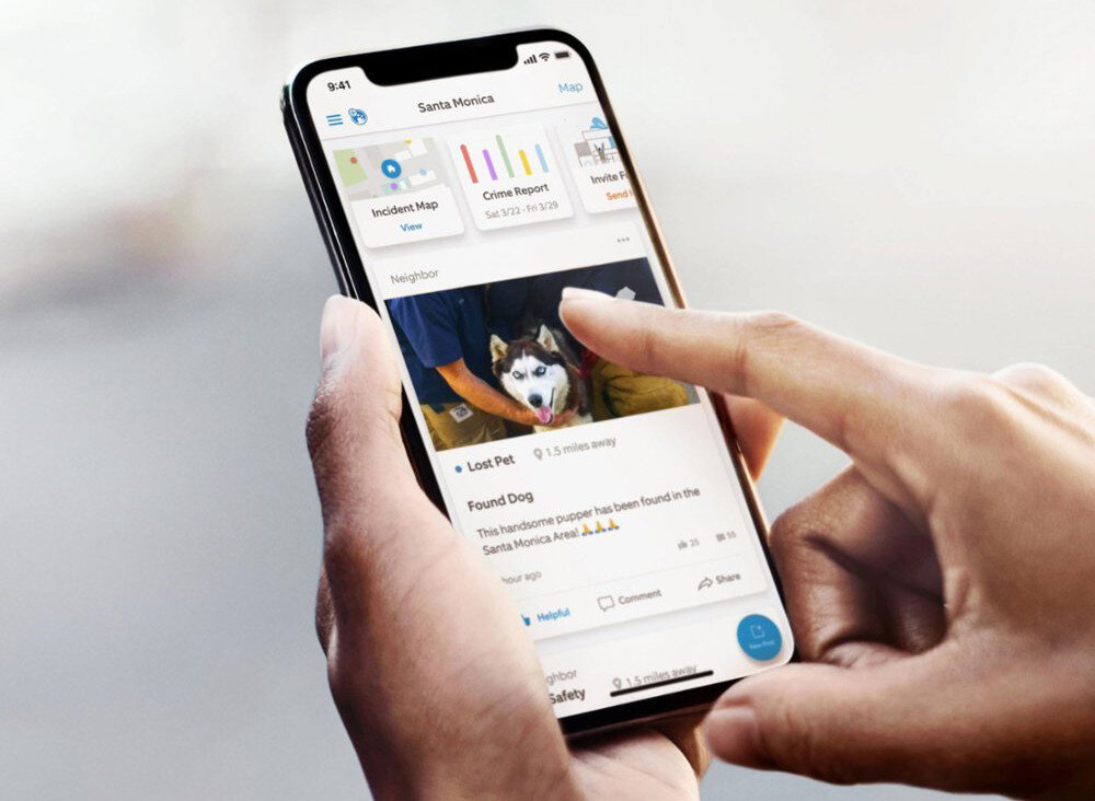 Osoba trzyma smartfon, na którym wyświetlana jest aplikacja z informacjami o zagubionym psie. Na ekranie widoczny jest tekst: \'Lost Pet\' i \'Found Dog\'.