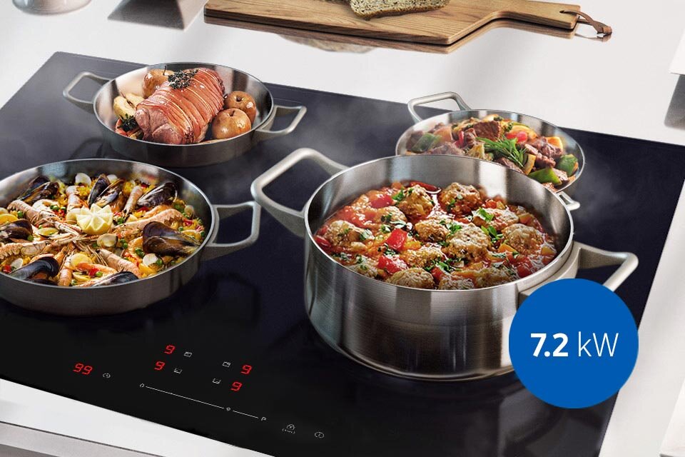 Na płycie indukcyjnej znajdują się cztery garnki z różnymi potrawami. Na obrazie widoczny jest niebieski okrąg z napisem \'7.2 kW\'.