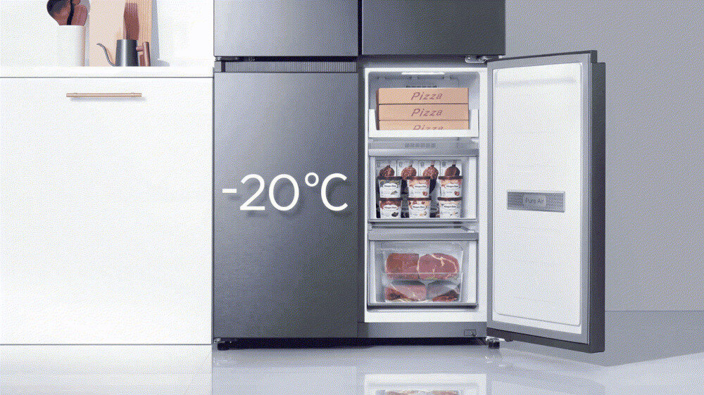 Otwarta lodówka z widocznymi produktami spożywczymi, takimi jak pudełka pizzy, lody i mięso. Na drzwiach lodówki widoczny jest napis \'-20°C\'.
