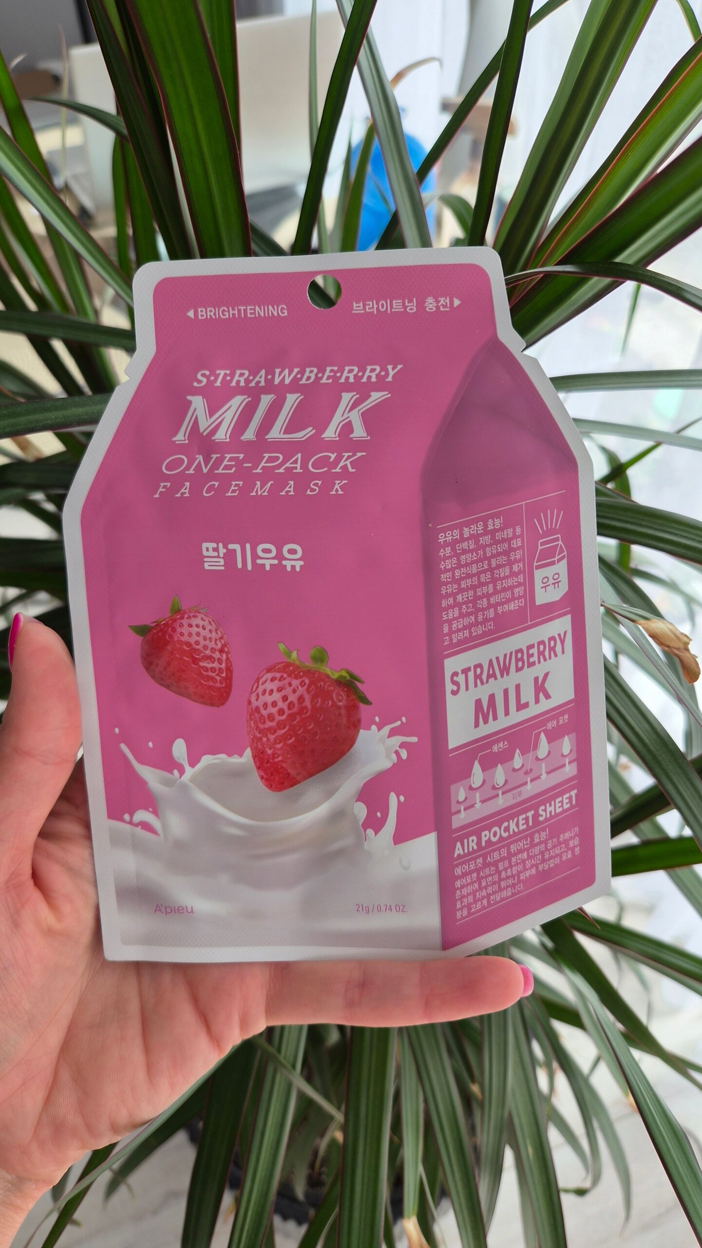 Opakowanie maseczki w płachcie o nazwie \'Strawberry Milk One-Pack Face Mask\' z grafiką truskawek i mleka. Widoczny tekst: \'BRIGHTENING\', \'STRAWBERRY MILK\', \'AIR POCKET SHEET\'.