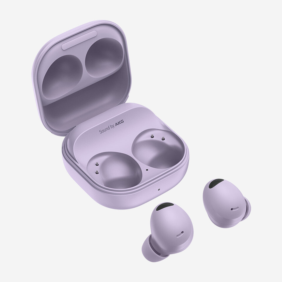 Na obrazie widoczne są bezprzewodowe słuchawki douszne w kolorze fioletowym wraz z otwartym etui ładującym. Na etui znajduje się napis \'Sound by AKG\'.