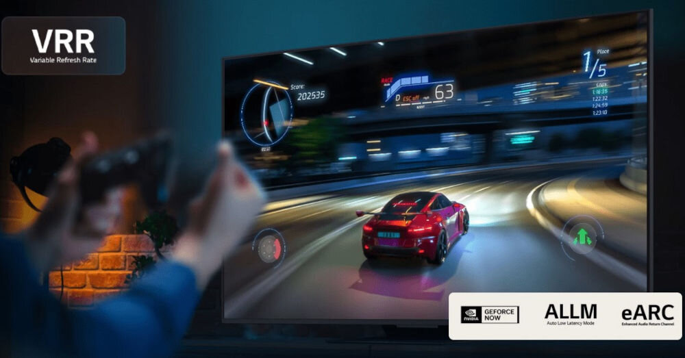 Osoba trzyma kontroler do gier przed telewizorem, na którym wyświetlana jest gra wyścigowa z czerwonym samochodem na torze. Na ekranie widoczne są napisy: \'VRR Variable Refresh Rate\', \'Score 202355\', \'63\', \'1/5\', \'GEFORCE NOW\', \'ALLM Auto Low Latency Mode\', \'eARC Enhanced Audio Return Channel\'.