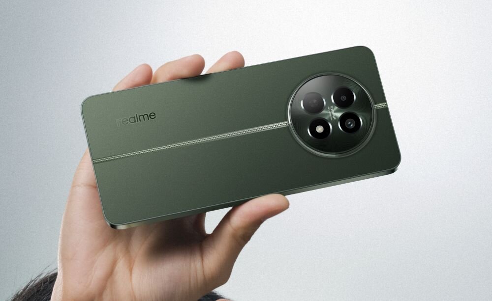 Osoba trzyma zielony smartfon z trzema aparatami w okrągłym module. Na obudowie widoczne jest logo \'realme\'.