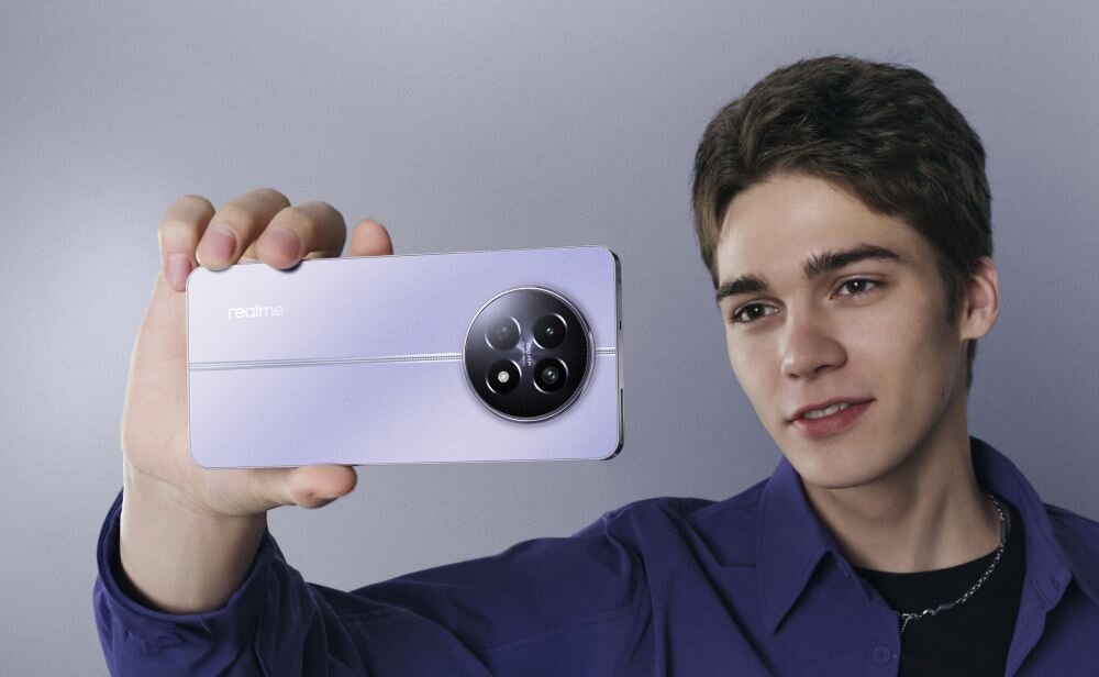 Osoba trzyma fioletowy smartfon z okrągłym modułem aparatu i logo \'realme\'.