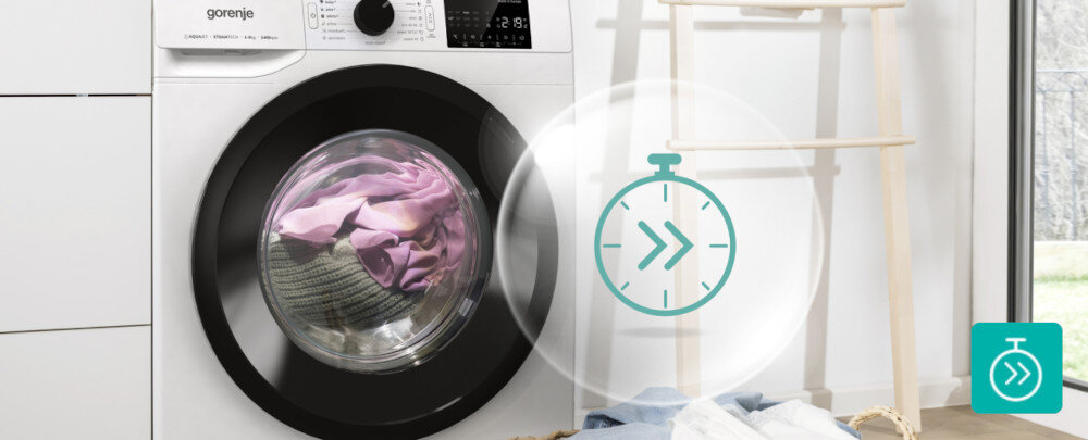 Pralka z widocznym logo \'gorenje\' i panelem sterowania, w bębnie znajdują się kolorowe ubrania. Obok pralki widoczna jest ikona zegara z podwójną strzałką wskazującą na funkcję szybkiego prania.