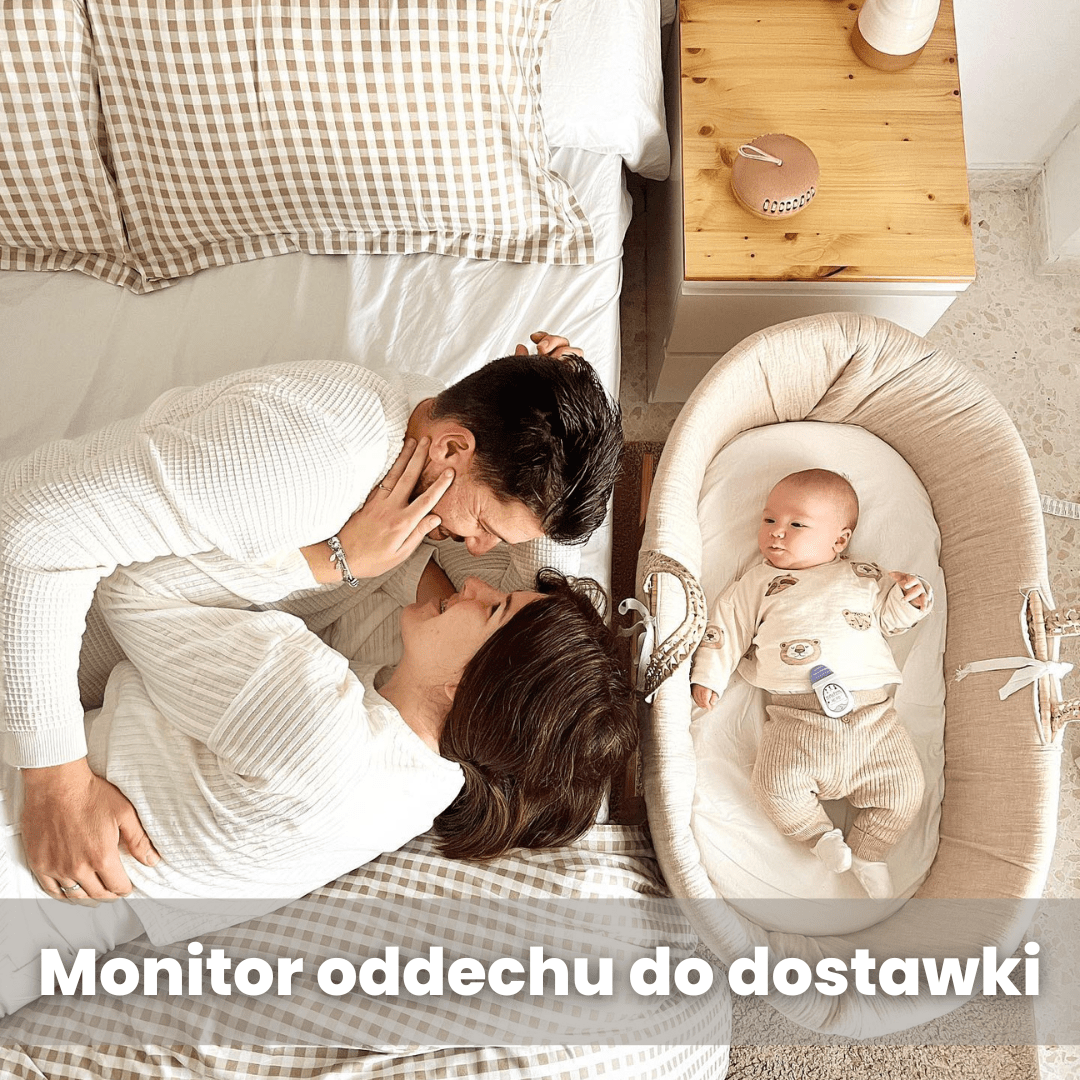 Na łóżku leży para dorosłych, obok znajduje się niemowlę w łóżeczku z monitorem oddechu przypiętym do ubranka. Na dole obrazu widoczny jest napis: \'Monitor oddechu do dostawki\'.